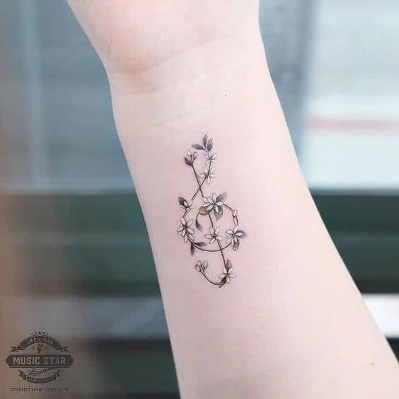tatuagem de clave de sol delicada com flores