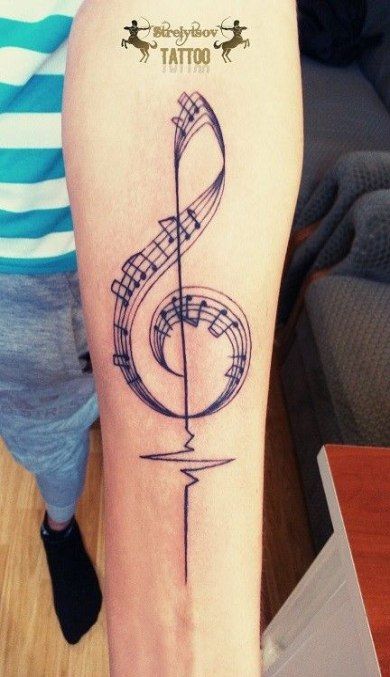 tatuagem no braço de clave de sol com notas musicais