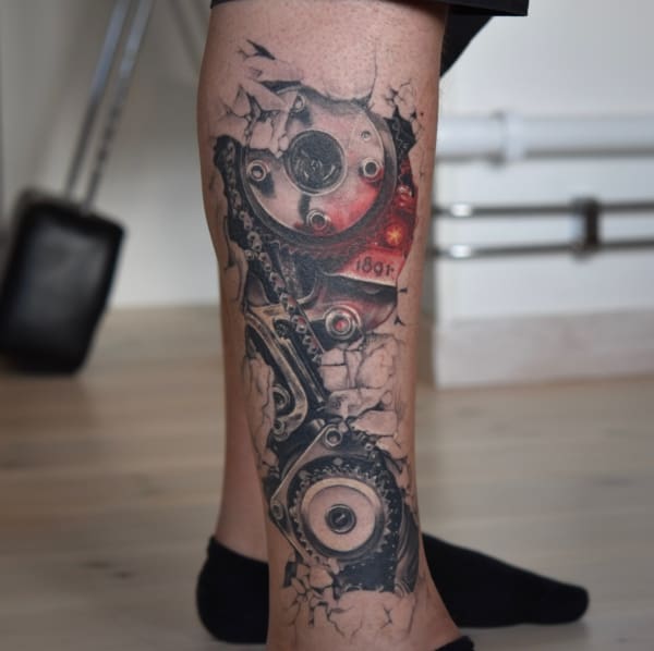 tatuagem masculina de engrenagens na perna