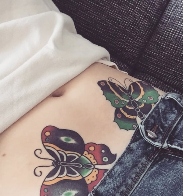 Duas tatuagens de borboleta na barriga