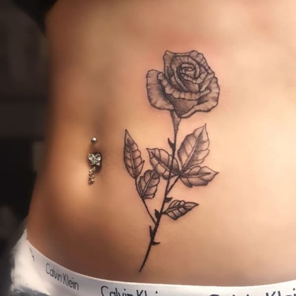 Flor delicada tatuada na barriga