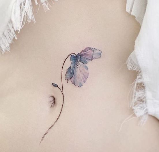 Flor roxa tatuada na barriga