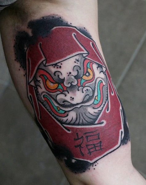 Tatuagem colorida masculina dragão daruma
