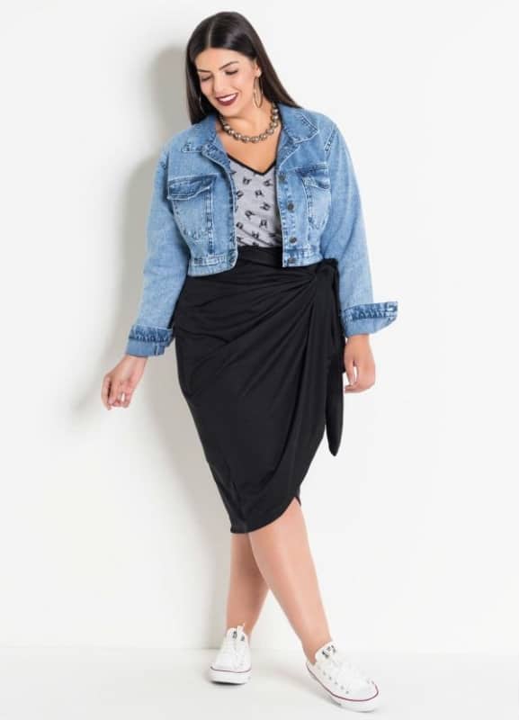 look plus size com saia pareô preta e jaqueta jeans