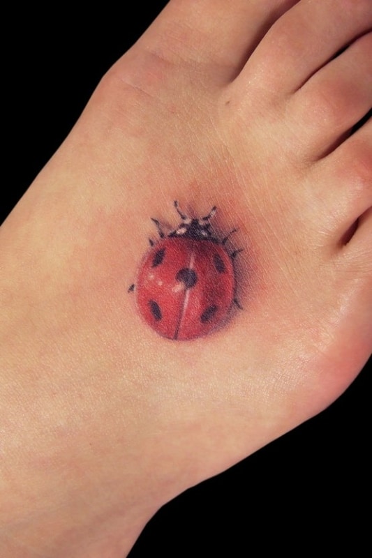 tatuagem de joaninha 3D no pé