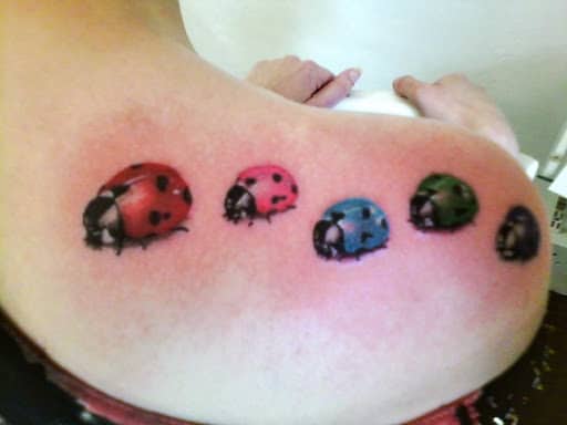 tatuagem de joaninha colorida nas costas