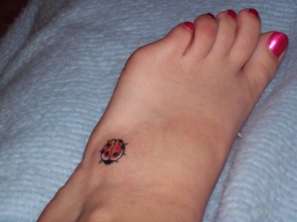 tatuagem de joaninha na lateral do pé