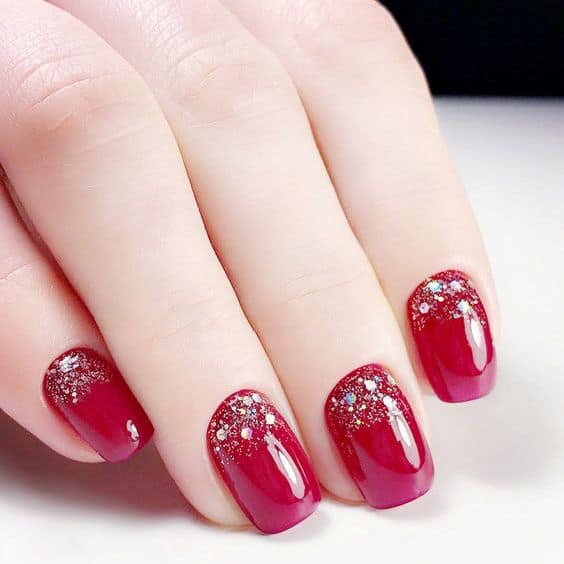 unhas decoradas com esmalte vermelho e glitter