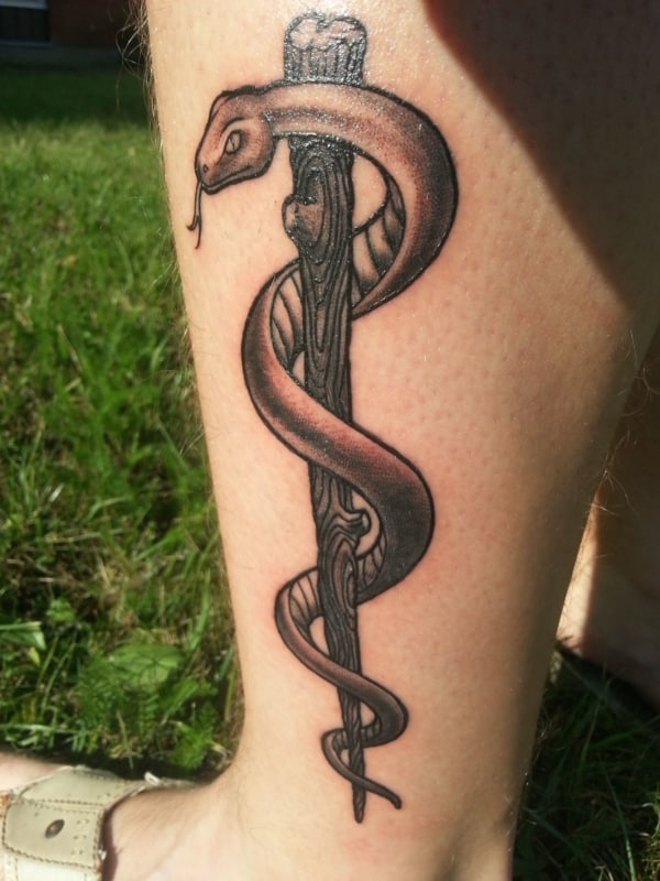 tatuagem na perna com Bastao de Asclepio