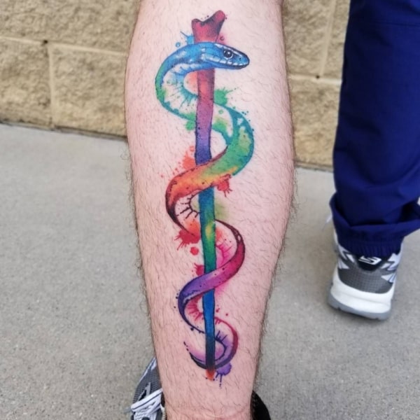 tatuagem colorida com Bastao de Asclepio simbolo da medicina