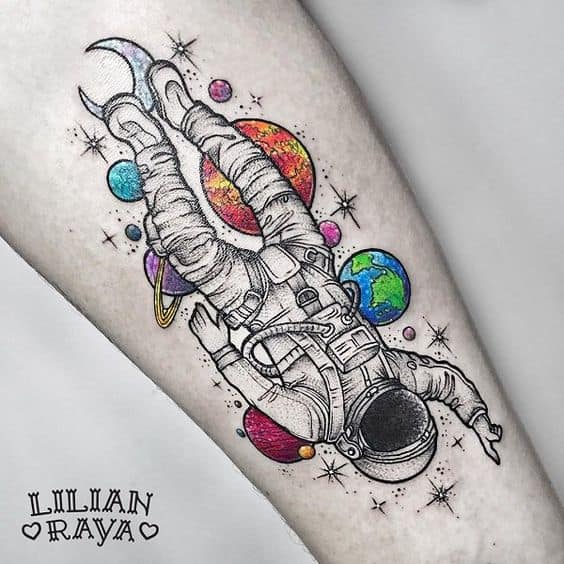 tatuagem de astronauta com planetas coloridos