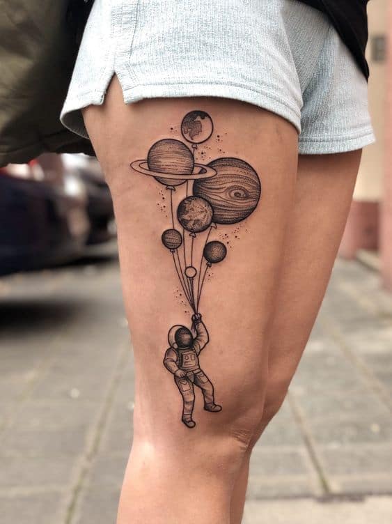 tatuagem grande na perna de astronauta com planetas