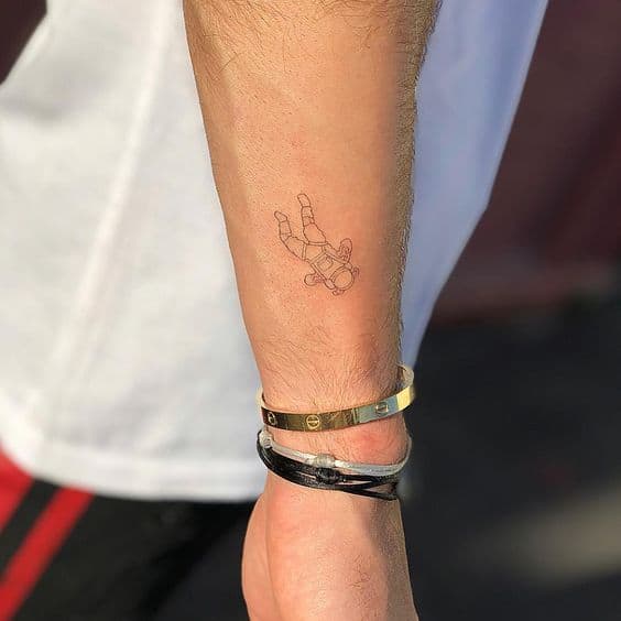tatuagem pequena de astronauta no braco