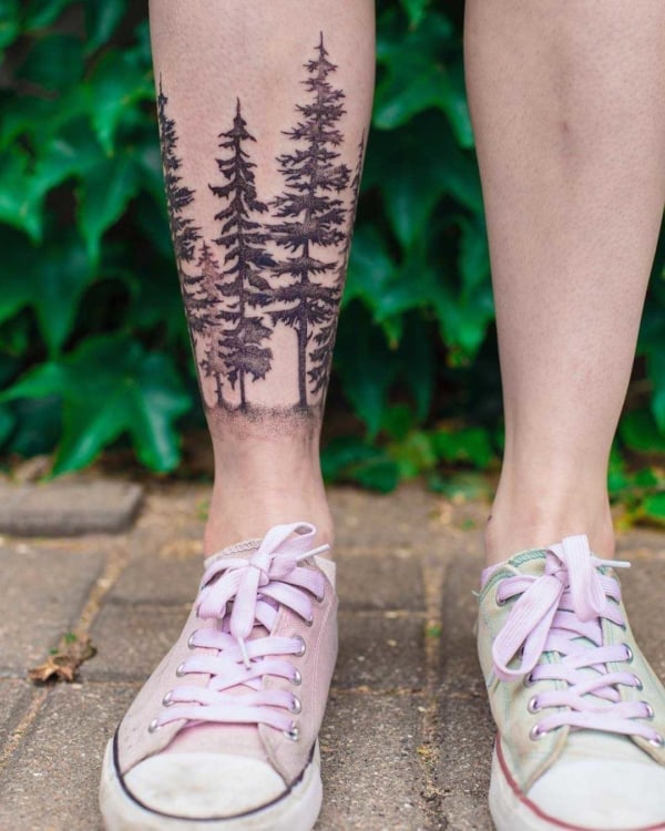 tatuagem feminina de floresta negra na perna