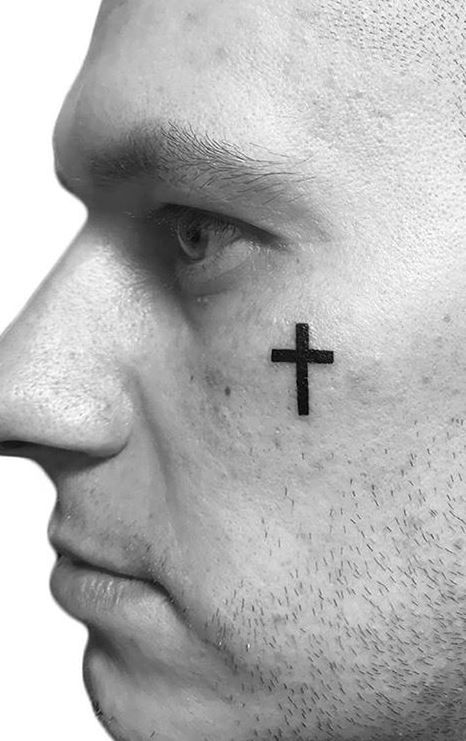 tattoo de cruz no rosto