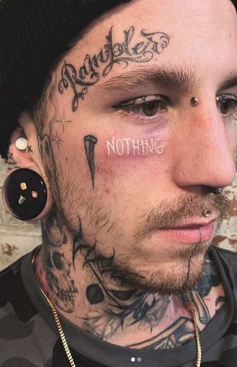 tatuagem escrita no rosto masculino