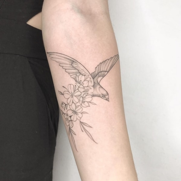 38 tatuagem feminina e delicada de andorinha com flores @ricardo di paulla tattoo