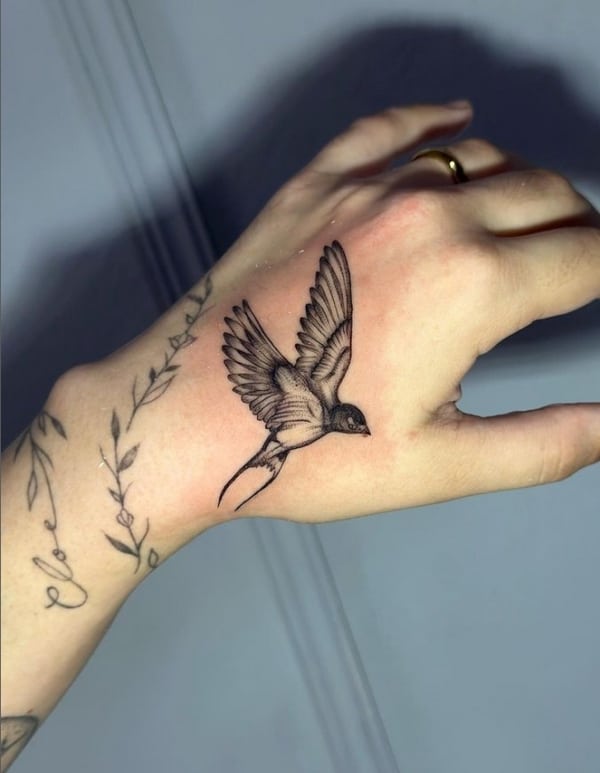 39 tatuagem feminina de andorinha na mão @studio novellis tattoo