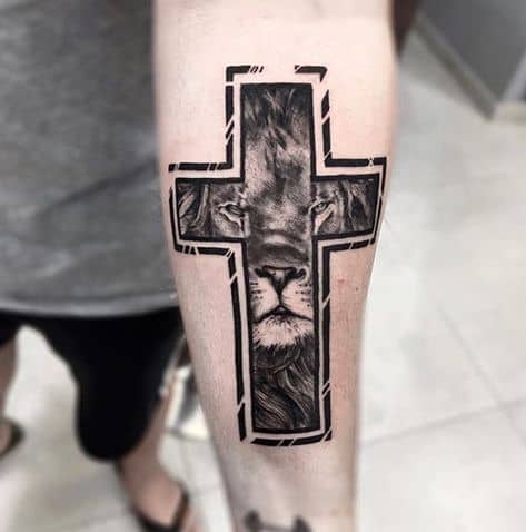 Tatuagem leão com cruz no braço sombreada