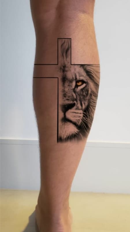 Tatuagem leão com cruz perna